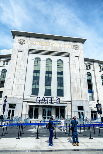 Three young, black, New York Yankees baseball fans taking photographs of each other in front of Yankee Stadium Gate 4 on May 24th, 2015. This newest Yankee Stadium building - opened in 2009 - is the iconic, internationally known home of the major league New York Yankees American League professional baseball team. Located in the Bronx, NY City, New York State, USA.