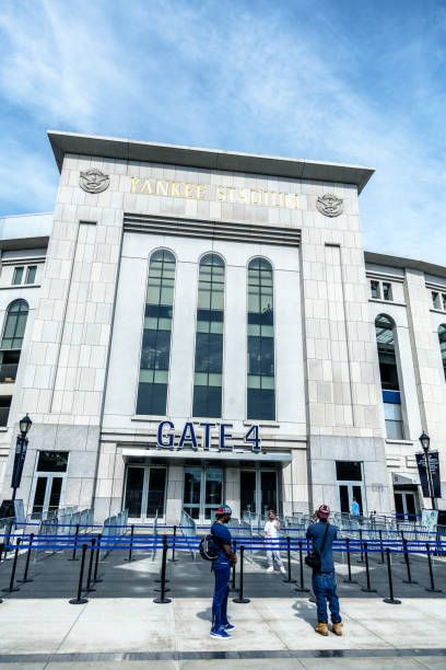 Young Black NY Yankees Fans Taking Snapshots at Yankee Stadium Three young, black, New York Yankees baseball fans taking photographs of each other in front of Yankee Stadium Gate 4 on May 24th, 2015. This newest Yankee Stadium building - opened in 2009 - is the iconic, internationally known home of the major league New York Yankees American League professional baseball team. Located in the Bronx, NY City, New York State, USA. american league baseball stock pictures, royalty-free photos & images