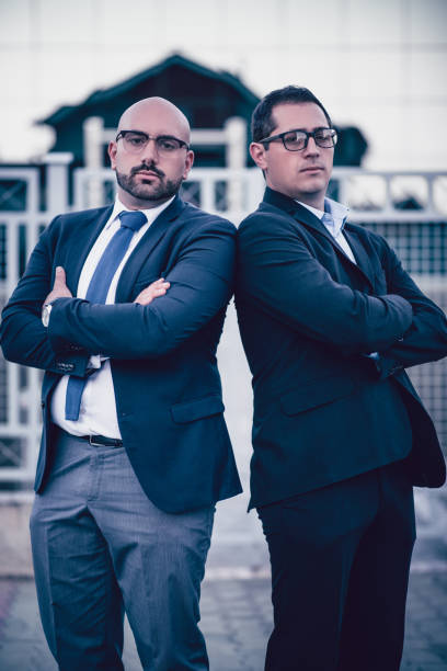 istock Two Serious Businessman With Crossed Hands Posing in front of Office Building 906537670