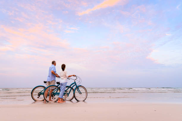 active couple with bikes - action mature adult bicycle senior couple imagens e fotografias de stock