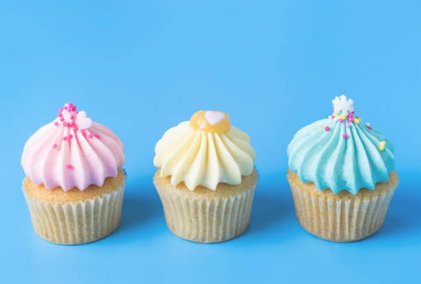 istock Three colorful fancy cupcake on blue background 906556874