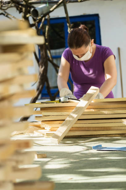 istock DIY - Home improvement; woman sanding wood plank 906559548