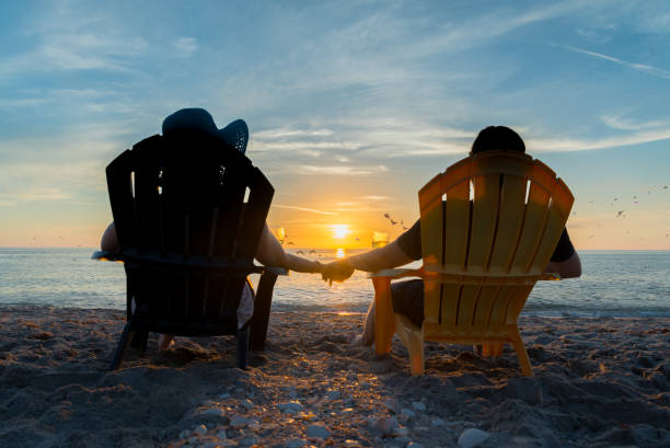 istock Couple Watching The Sunset On Beach 906570208