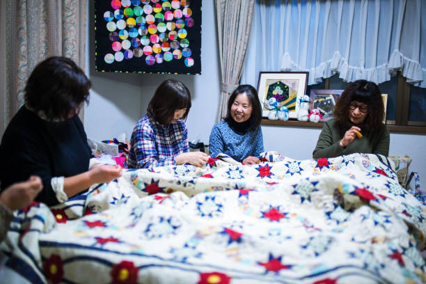 istock Senior women working together to make a patchwork quilt 906575152