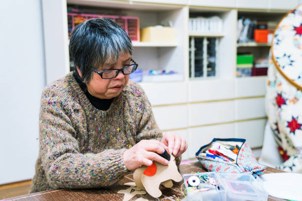 istock A senior woman sewing and making crafts in her home 906575280