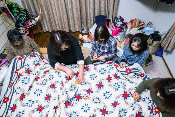istock Senior women working together to make a patchwork quilt 906575282