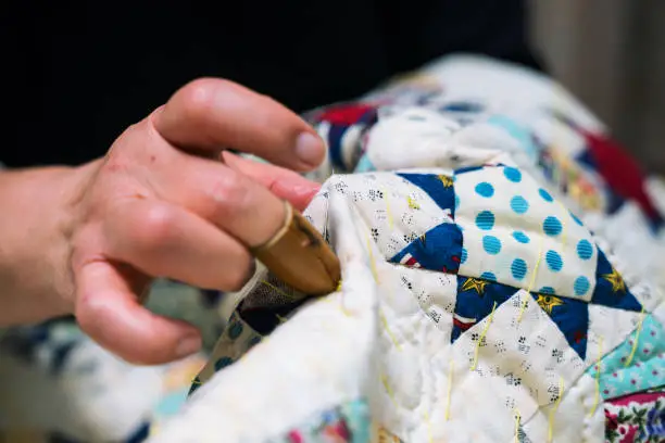 A close-up shot of a senior woman sewing and making crafts in her home