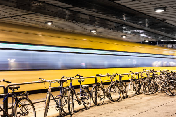 Parked bicycles at an underpass and in the background a moving tram