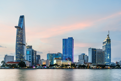 Ho Chi Minh City skyline and the Saigon River at sunset. Beautiful view of skyscraper and other modern buildings at downtown. Ho Chi Minh City is a popular tourist destination of Vietnam.