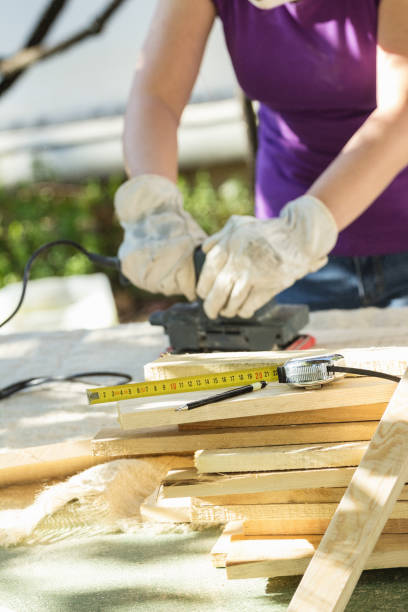 istock DIY - Home improvement; woman sanding wood plank 906580868