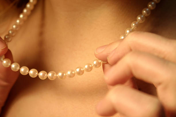 frau trägt einen perlen-halskette - pearl jewelry necklace women stock-fotos und bilder