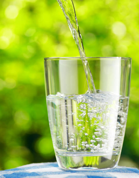 istock Glass of water on nature background 906588698