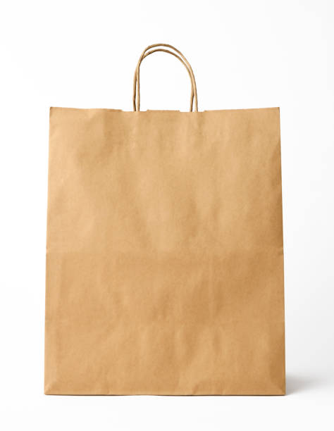 isolated shot of brown paper shopping bag on white background - paper bag fotos imagens e fotografias de stock