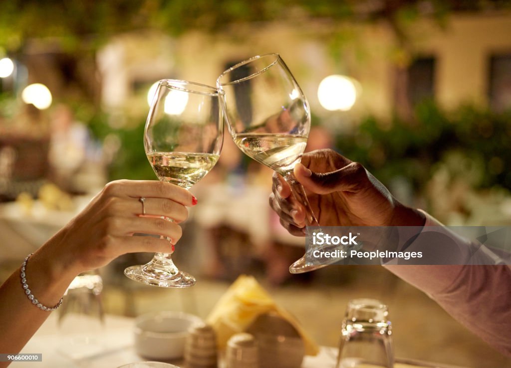 This date couldn't go any better Cropped shot of a couple making a toast while on a romantic date Wine Stock Photo