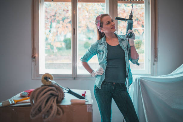 istock Woman with an electric drill renovating home 906602604