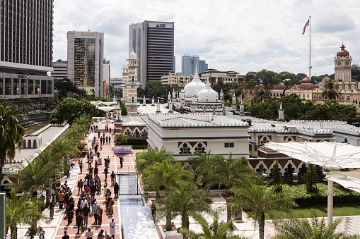 Kuala Lumpur, Malaysia - December 22 2017: Muslims leave the Jamek mosque (Masjid) after the Friday prayer in the heart of Kuala Lumpur business and financial district in Malaysia.