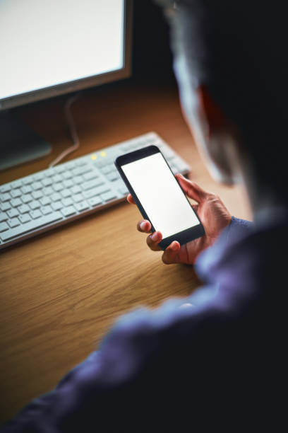 istock Backview of man with phone and computer at night 906603240