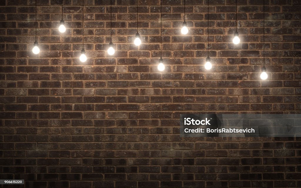 Shining light bulbs on dark brick wall. 3d rendering Light Bulb Stock Photo