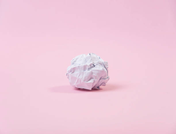 istock crumpled paper ball on pink background. concept idea and creative. 906618952