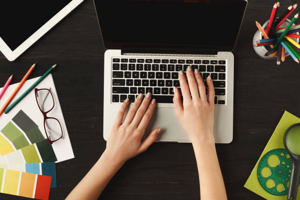 istock Woman's hands on laptop keyboard, top view 906621880