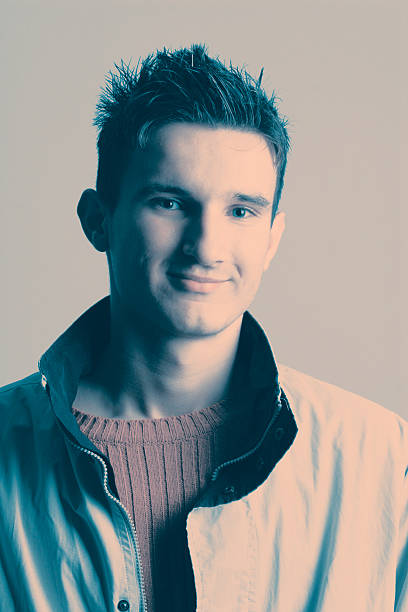 Cool young man dressed in white t-shirt resting his head on his hand
