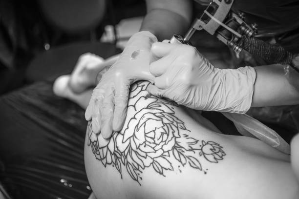 istock Professional tattoo artist making a tattoo in studio 906631982