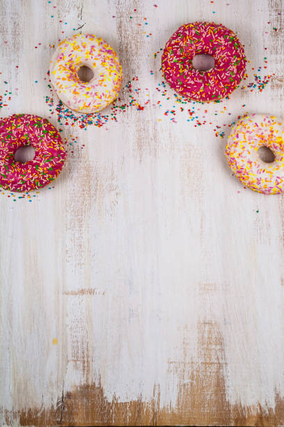 Multicolored donuts close-up Multicolored donuts close-up on a wooden background. Delicious dessert. alcorza stock pictures, royalty-free photos & images