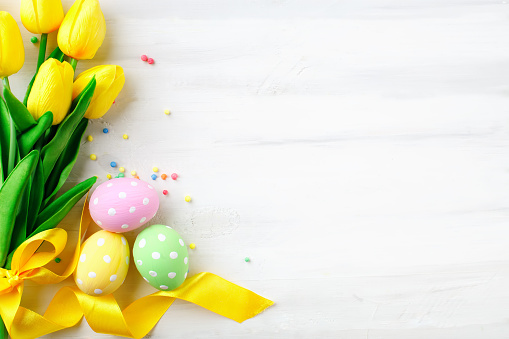 Happy Easter. Congratulatory easter background. Easter eggs and flowers. Background with copy space.