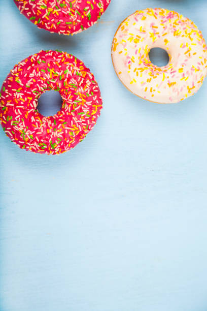 Multicolored donuts close-up Multicolored donuts close-up on a blue wooden background. Delicious dessert. alcorza stock pictures, royalty-free photos & images