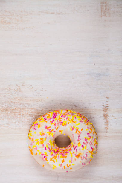 Donut close-up on a wooden background. Donut close-up on a wooden background. Delicious dessert. alcorza stock pictures, royalty-free photos & images