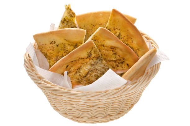 Sliced Italian Homemade bread: tortilla or fokacho, focaccia lie in a basket on a napkin on a white background