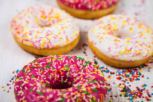 Multicolored donuts close-up Multicolored donuts close-up on a wooden background. Delicious dessert. alcorza stock pictures, royalty-free photos & images