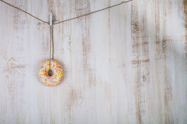Donut on a rope Donut on a rope on a wooden background. Delicious and sweet dessert. alcorza stock pictures, royalty-free photos & images