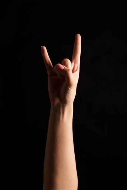 istock Woman making rock gesture at black isolated background 906635580