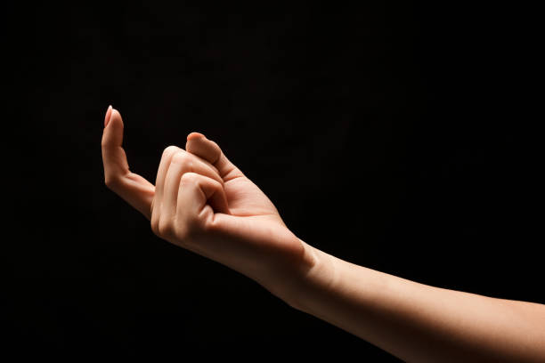 istock Female hand beckoning isolated on black background 906637768