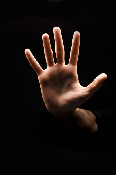 istock Man making stop sign with his hand at black background 906638268