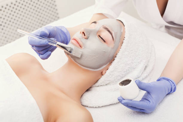 istock Woman gets face mask by beautician at spa 906640664