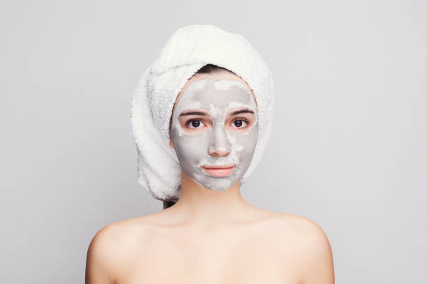 istock Beautiful girl with applied clay mask at white background 906640758