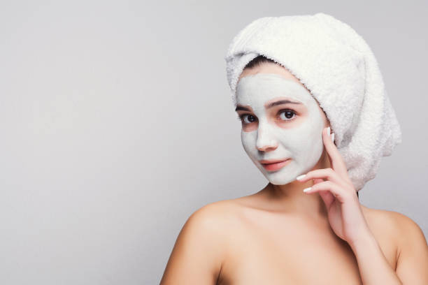 istock Beautiful girl with applied clay mask at white background 906640826