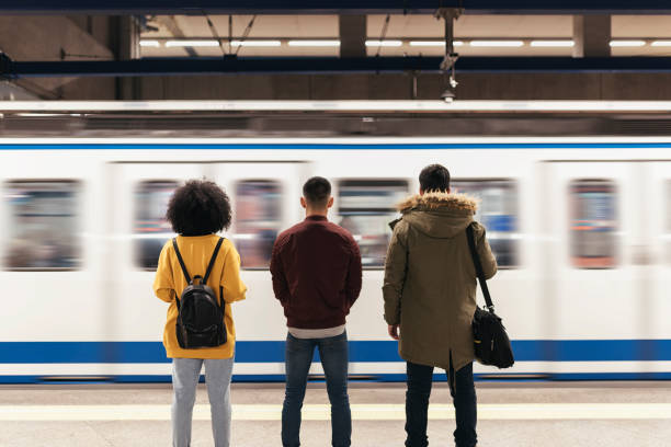 gruppo di amici in attesa del treno sulla banchina della stazione della metropolitana. - travel the americas human age viewpoint foto e immagini stock