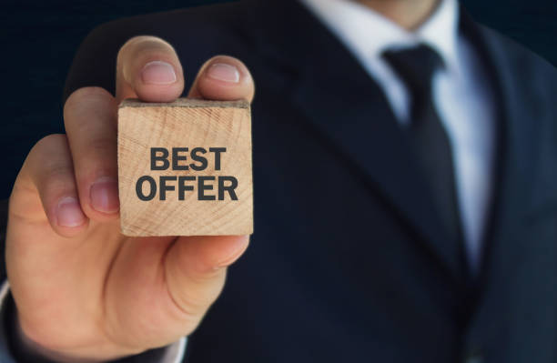 istock Man holding best offer text on a wood cube. 906648822
