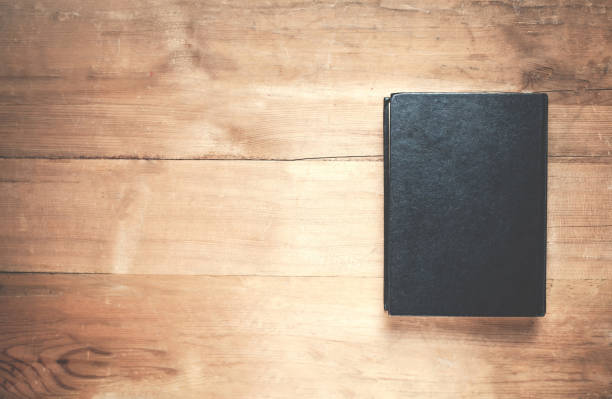 istock Black book on the wooden background. 906648896