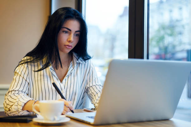 istock Professional business woman searching information in network concentrated on solving problems.Attractive serious female entrepreneur doing remote job planning financial report in coffee shop 906651780