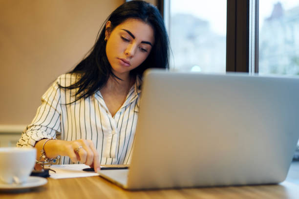 istock Concentrated female executive manager making researchers using modern technology in cafe.Beautiful business woman planning startup project solving problems with organization sitting in cafe interior 906651982