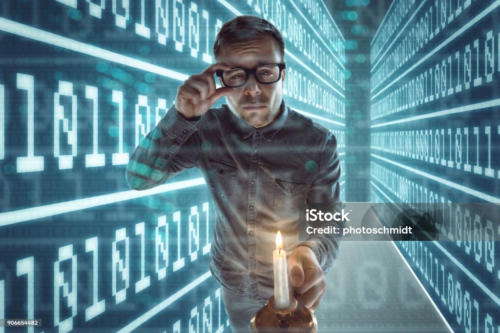 Nerd gets lost in cyberspace Computer Nerd with glasses and a candle in one hand is walking through a maze with walls made out of binary code. Lost Stock Photo