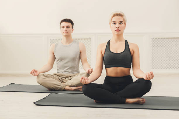 istock Young couple meditating together in studio 906654662