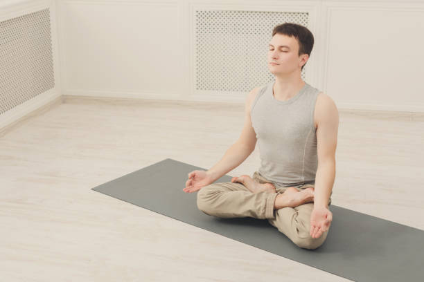 istock Young man in yoga class, relax meditation pose 906655192