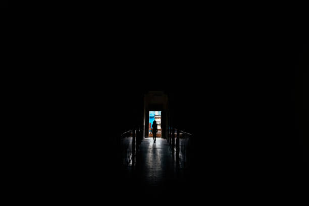 istock Woman walking alone in dark hall. Silhouette Concept. 906655936
