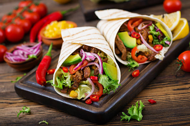 Mexican tacos with beef in tomato sauce and avocado salsa Mexican tacos with beef in tomato sauce and avocado salsa fajita photos stock pictures, royalty-free photos & images