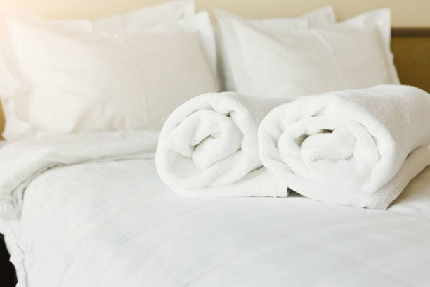 White towels on wooden surface over blurred bedroom interior background